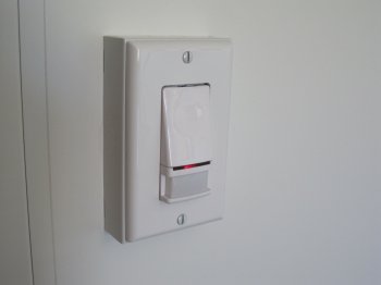 Photo of a vacancy sensor light switch on the wall surface.